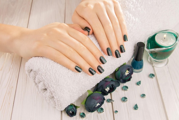 Manicure per occhi di gatto verde su sfondo di legno bianco nail art design