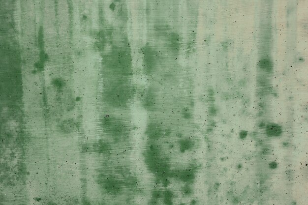 The green cement wall is dirty.