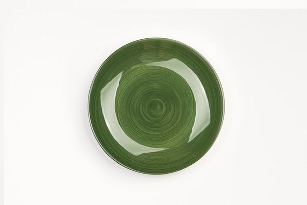 A green ceramic round dish on a white background in a top view