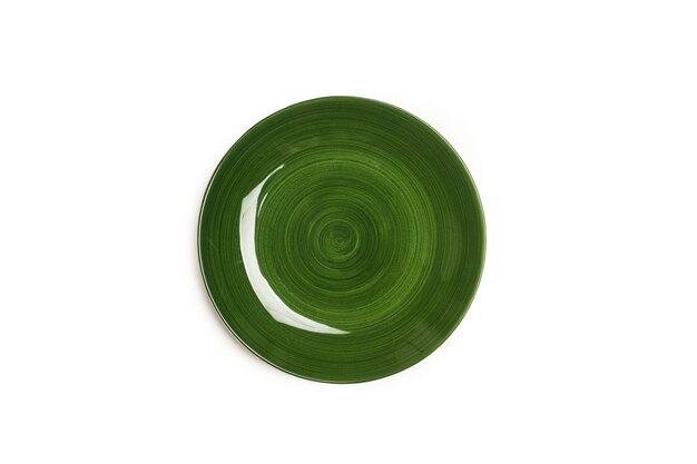 A green ceramic round plate on a white background in a top view