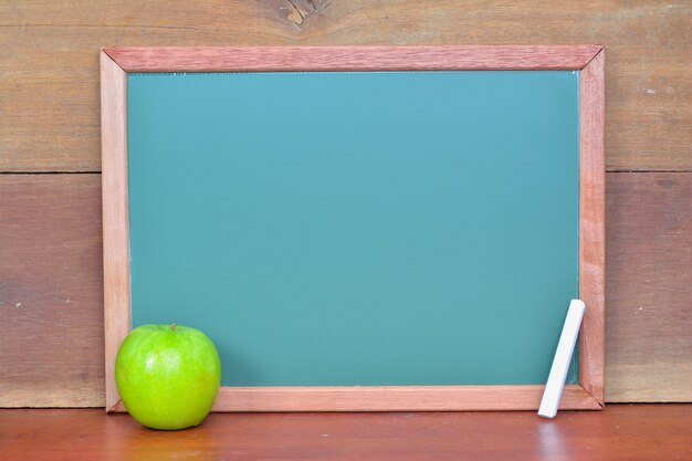 Green chalkboard on wooden background