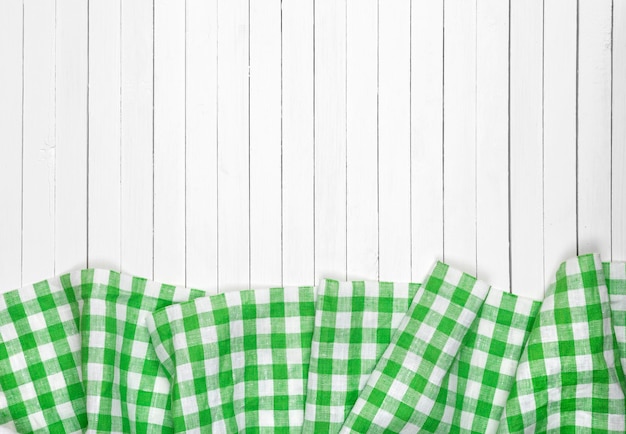 Green checkered tablecloth on wooden table top view