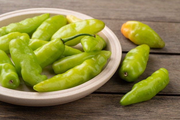 Green cheiro scentsmell pepper on a plate over wooden table