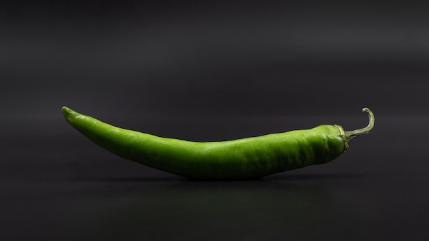 Green chili pepper on a gray background