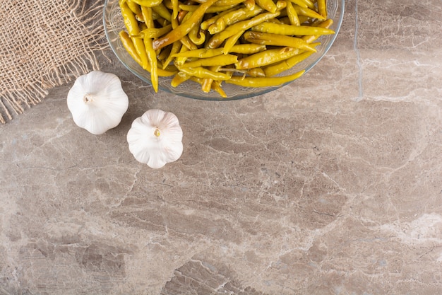 Green chili pepper pickled placed on stone table.