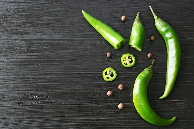 Green chili peppers on dark wooden background