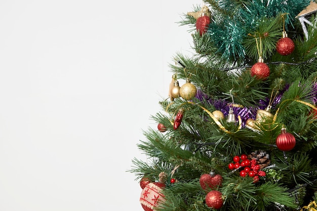 Green Christmas tree with xmas decorations, baubles and garlands. Christmas and New year tree on white background with copy space