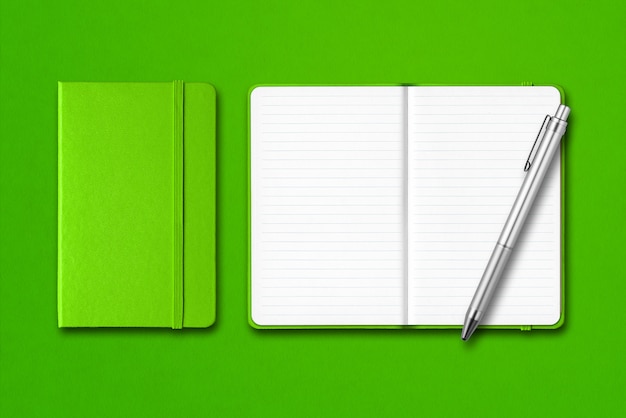 Green closed and open notebooks with a pen