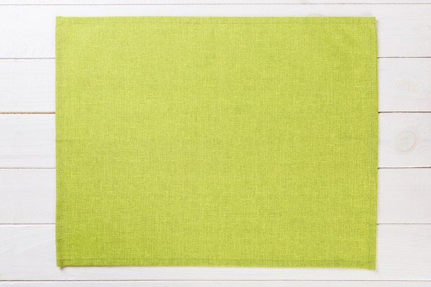 コピースペースを持つ白い素朴な木製トップビューに緑の布ナプキン