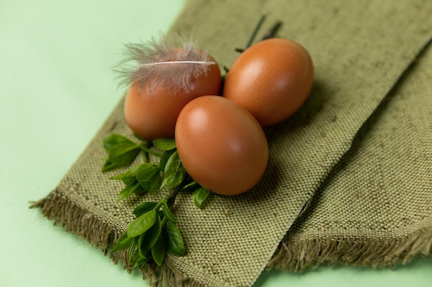 A green cloth with brown eggs and a feather on it