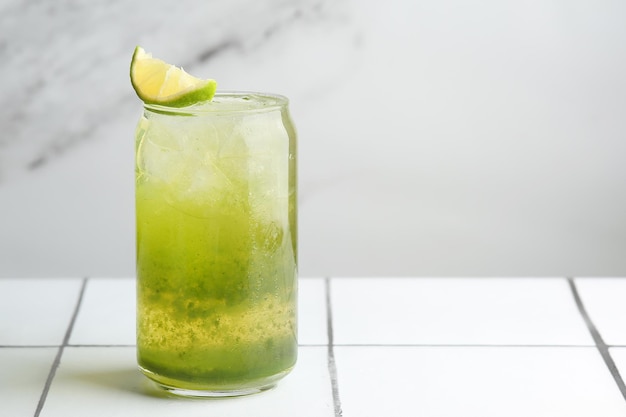 Green cocktail or lemonade with lime on light background closeup. Green Gin cocktail on bar table