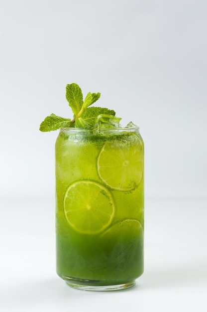 Green cocktail with lime syrup and soda with ice cubes