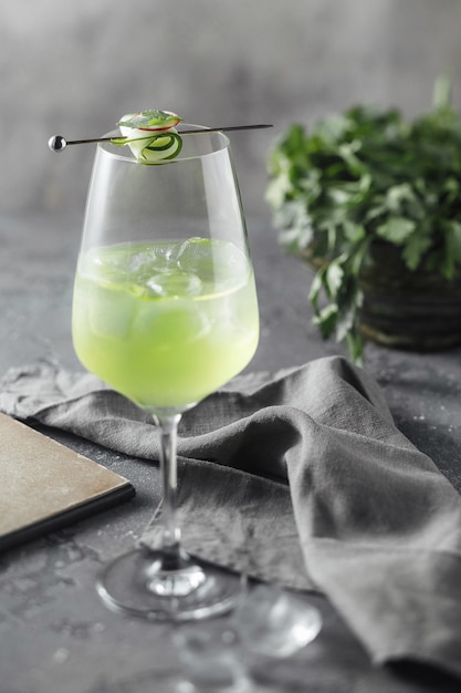 Photo green cocktail with a slice of cucumber near parsley leaf