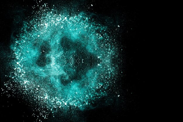 Green color powder explosion on black background.