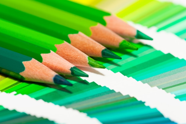 Green colored pencils and color chart of all colors