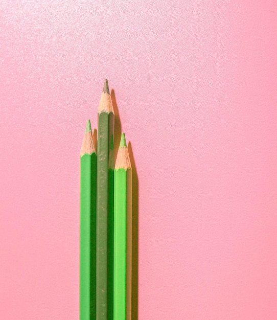 Photo green-coloured pencils on pink background