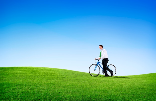 Bicicletta di riciclaggio dell'uomo di affari di concetto verde all'aperto