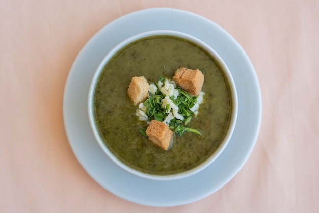 Green cream soup from spinach with croutons cheese and fresh parsley