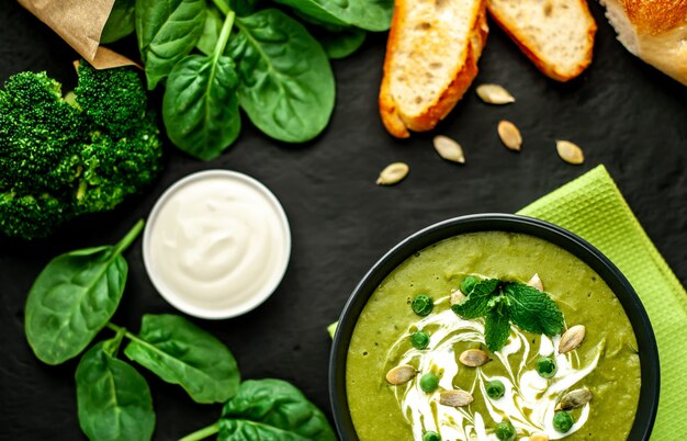 Green cream soup of spinach and broccoli. concrete or slate background. The concept of a healthy diet and diet.