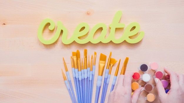 Green create sign with paint brushes on the table.