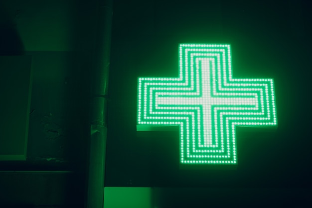 Photo green cross sign on a building of pharmacy.