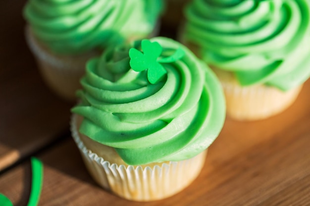 green cupcakes and shamrock on wooden table