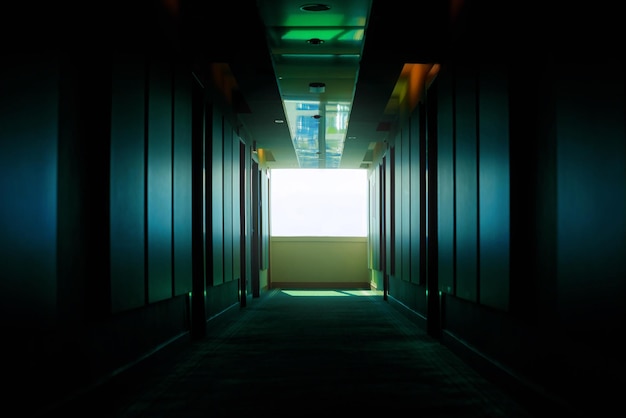 Green dark empty corridor in a hotel in perspective floor in a\
hotel a window in the hallway the light at the end of the\
tunnel