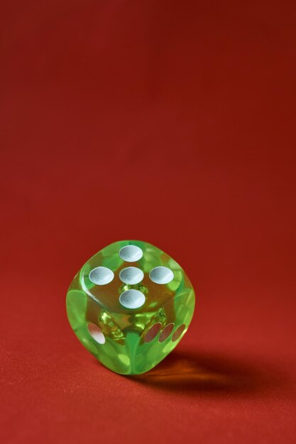 A green dice on a red background