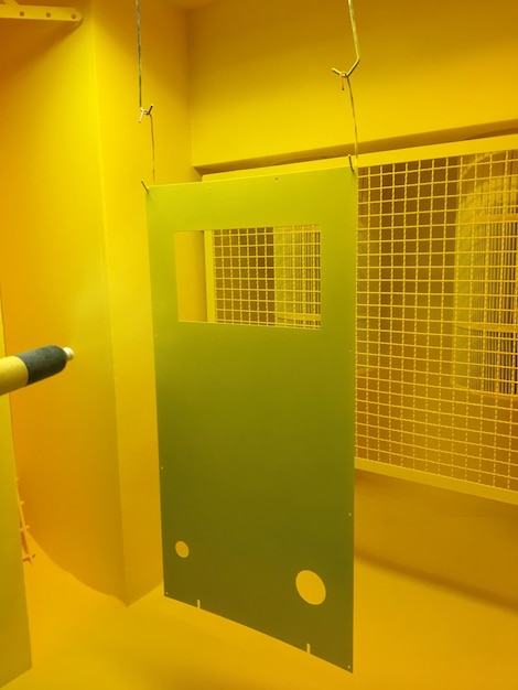 A green door is above a yellow ceiling.