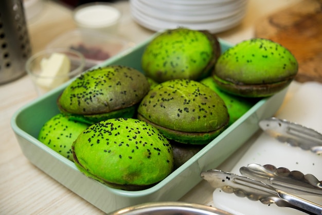 Photo green dough buns with black sesame seeds on wooden table