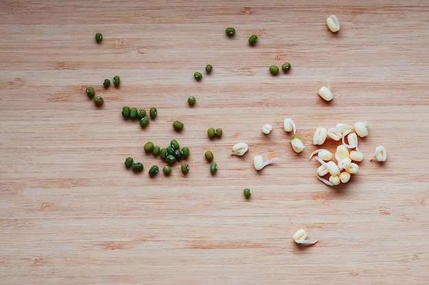 Photo green dry mung beans and their sprouts scattered on a table top view copy space