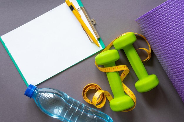 Green dumbbells on a dark gray paper background