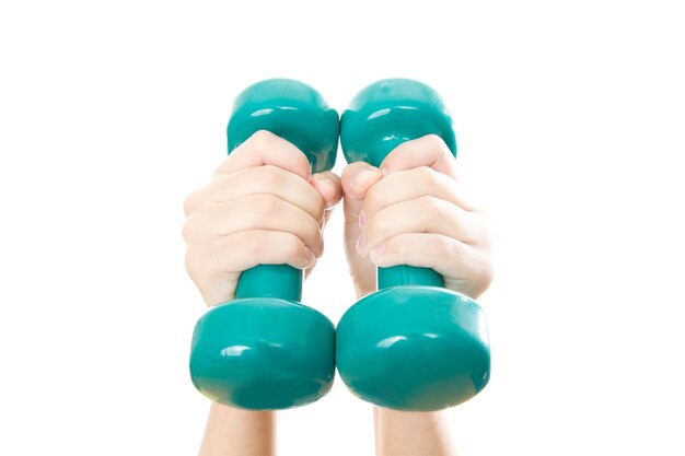 Green dumbbells in female hands isolated on white