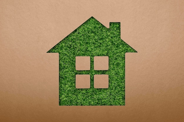 Green ecological house symbol green grass house symbol on paper texture background eco energy and en