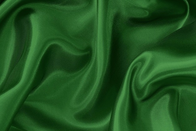 Green emerald fabric texture background, crumpled pattern of silk or linen.