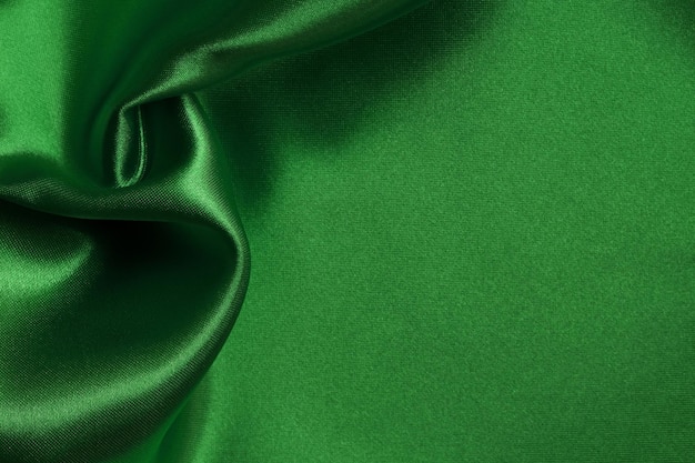 Green emerald fabric texture background crumpled pattern of silk or linen