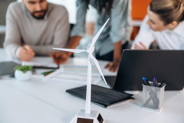 green energy model of wind turbine people are working in the office together