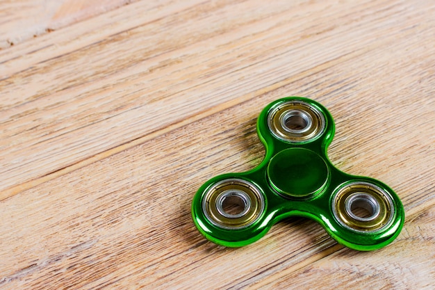 Green fidget spinner on a wood