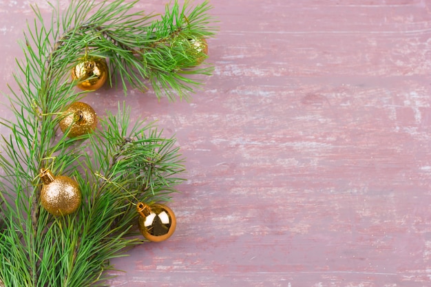 Green fir branches with golden christmas  balls frame  