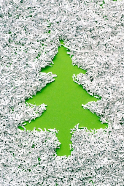 Green fir tree made from background under shredded paper heap