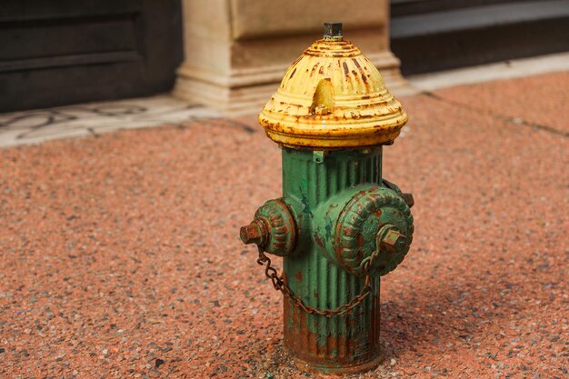 A green fire hydrant with a chain on it