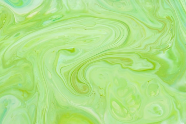 Green fluid art background. Liquid abstract pattern with UFO green. Marble texture of liquid surface. Fluid art