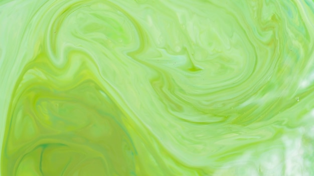 Green fluid art background. Liquid abstract pattern with UFO green. Marble texture of liquid surface. Fluid art