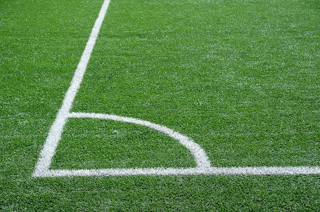 Green football field with white marking lines 