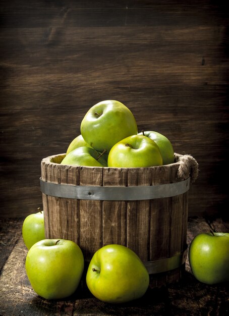 木製のバケツに緑の新鮮なリンゴ
