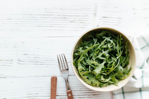 Green fresh arugula salad leaves in bowl