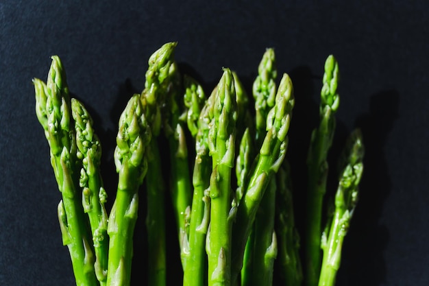 Green fresh asparagus isolated on black background