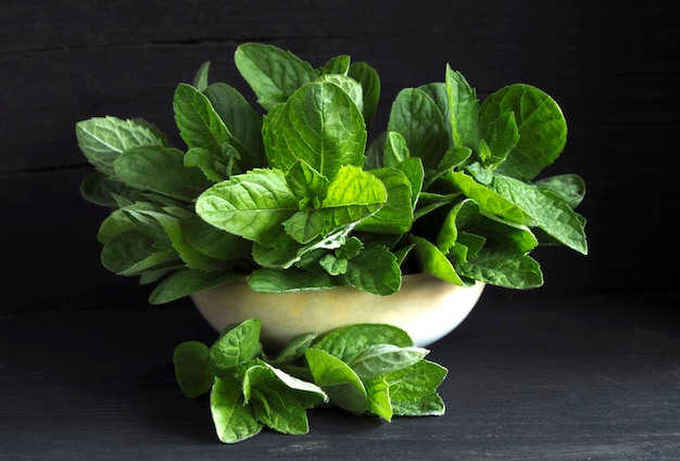 Green fresh mint on a black wooden table.