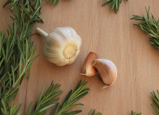 Green fresh rosemary with garlic on a wooden board