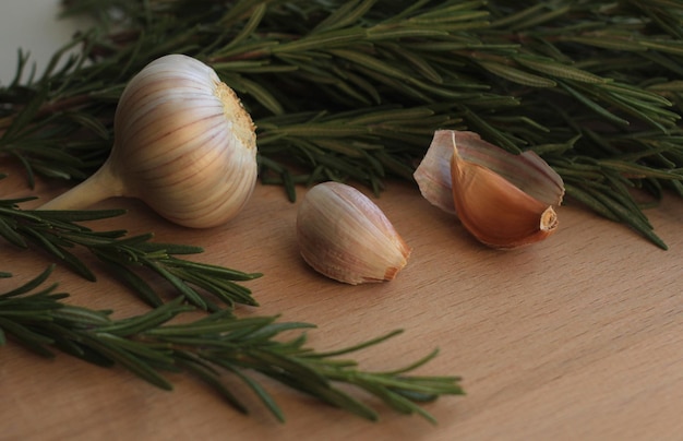 Green fresh rosemary with garlic on a wooden board